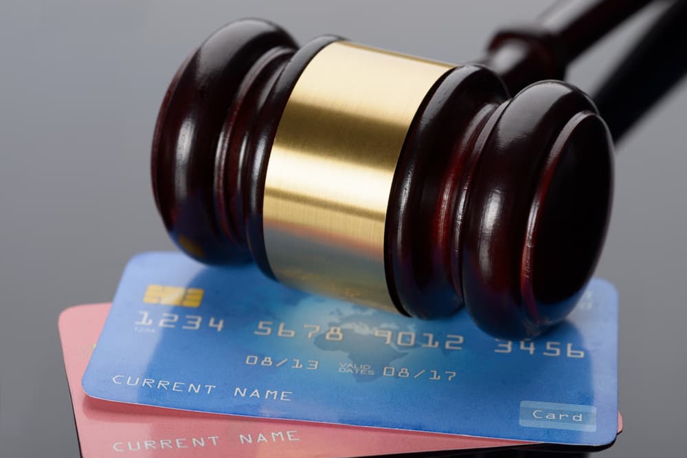 Close-up view of a wooden gavel placed amidst credit cards.